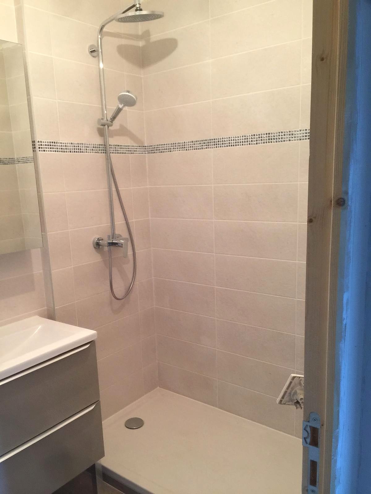 Douche carrelée beige avec meuble suspendu