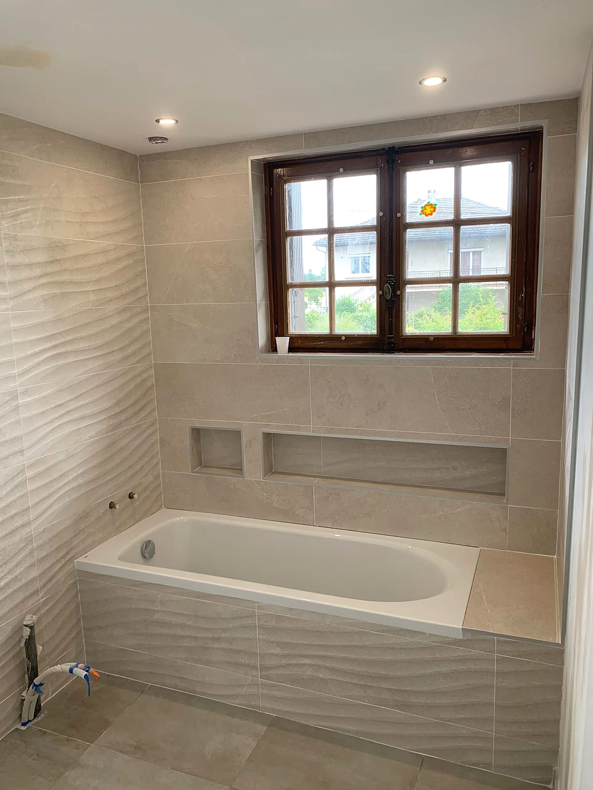Salle de bain avec baignoire et carrelage beige