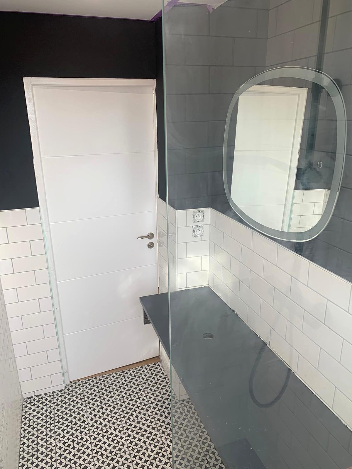 Salle d’eau carrelage métro avec miroir rond