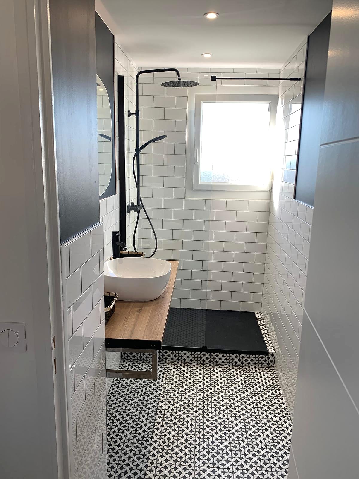 Salle d’eau — carrelage métro blanc, robinetterie noire et sol à motifs